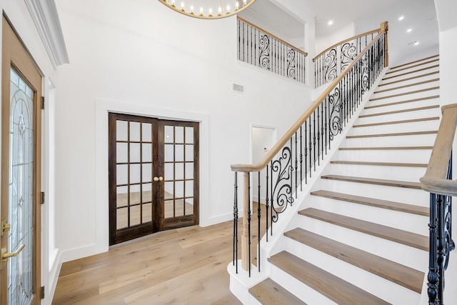 entrance foyer featuring french doors, recessed lighting, visible vents, light wood-style flooring, and a high ceiling