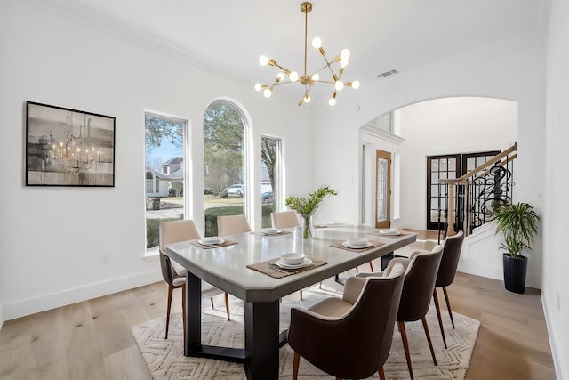 dining room with light wood-style floors, a wealth of natural light, visible vents, and a notable chandelier