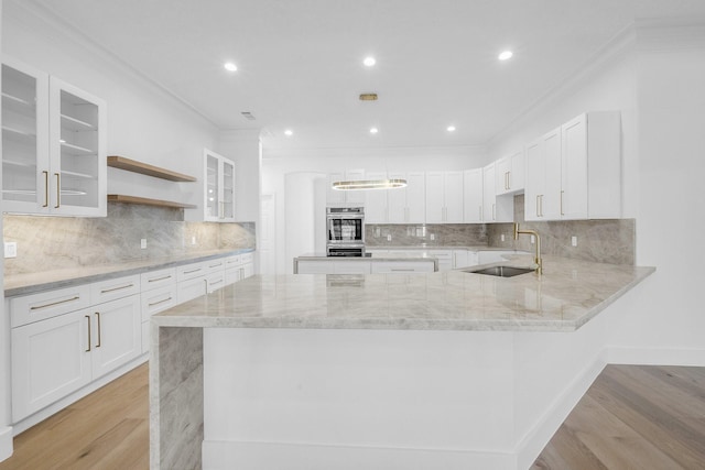 kitchen featuring glass insert cabinets, white cabinetry, open shelves, and a sink