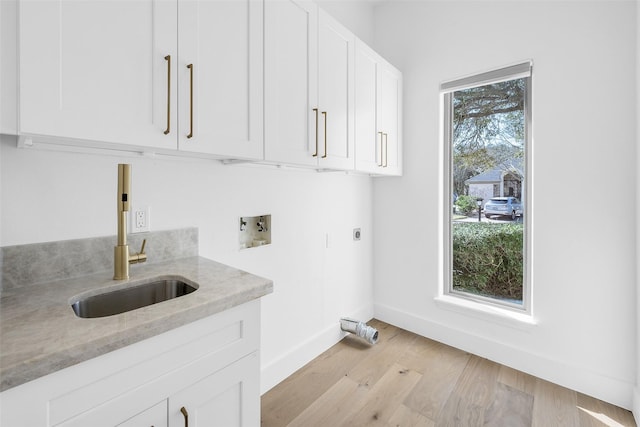 washroom featuring cabinet space, hookup for a washing machine, electric dryer hookup, light wood-type flooring, and a sink