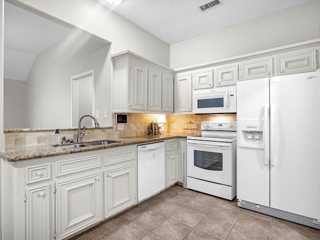 kitchen featuring white appliances, a sink, light stone counters, and white cabinetry