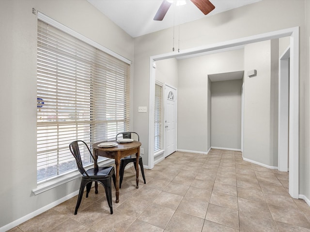 dining room with light tile patterned flooring, a ceiling fan, and baseboards