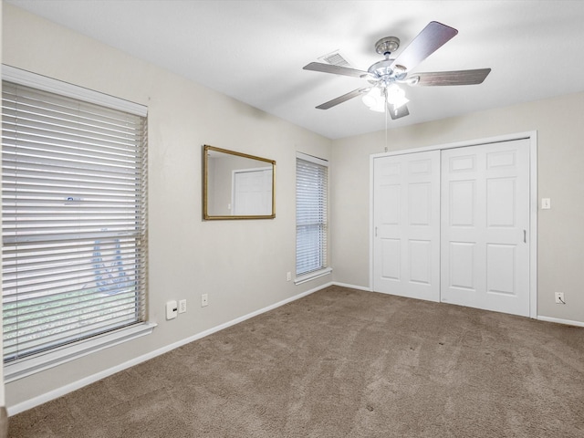 unfurnished bedroom featuring carpet, a closet, ceiling fan, and baseboards