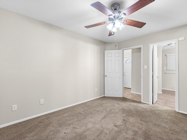 unfurnished bedroom featuring ceiling fan, baseboards, and light colored carpet