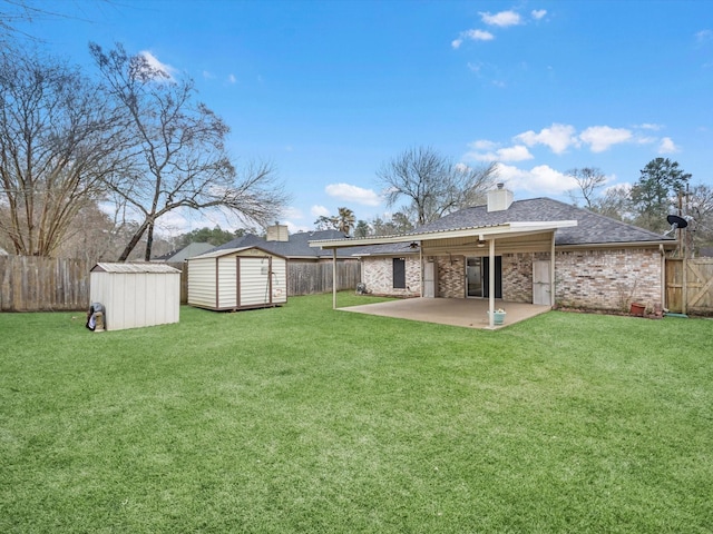 view of yard with a storage shed, a patio area, an outdoor structure, and a fenced backyard