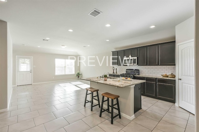 kitchen with light tile patterned floors, visible vents, appliances with stainless steel finishes, light stone counters, and backsplash