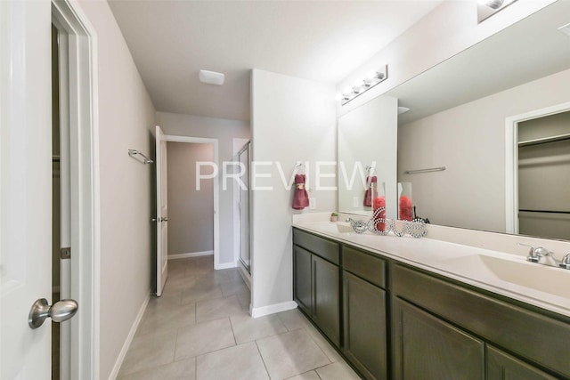 full bath featuring double vanity, tile patterned flooring, a sink, and a shower stall