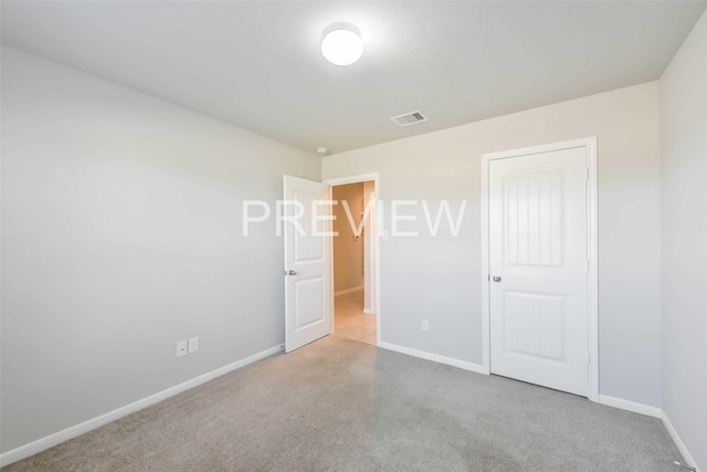 empty room featuring light carpet, baseboards, and visible vents