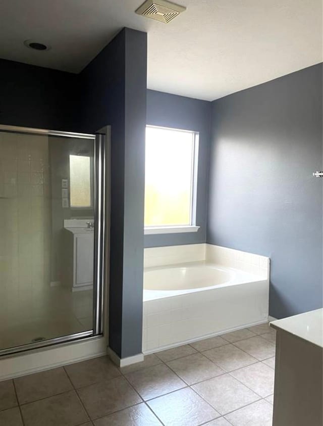 bathroom featuring a stall shower, visible vents, a bath, and tile patterned floors