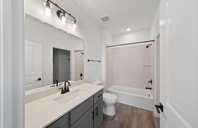 full bath with bathtub / shower combination, visible vents, toilet, vanity, and wood finished floors