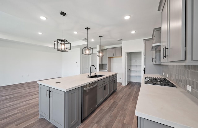 kitchen featuring gas cooktop, stainless steel dishwasher, a sink, and gray cabinetry