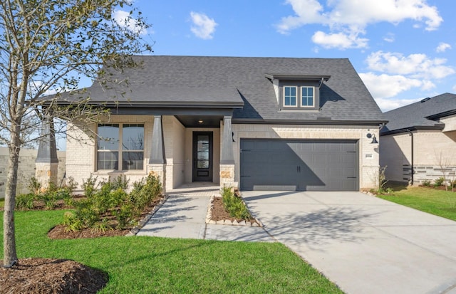 view of front of house with an attached garage, brick siding, concrete driveway, roof with shingles, and a front yard