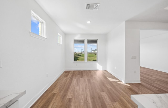 empty room with visible vents, baseboards, and wood finished floors