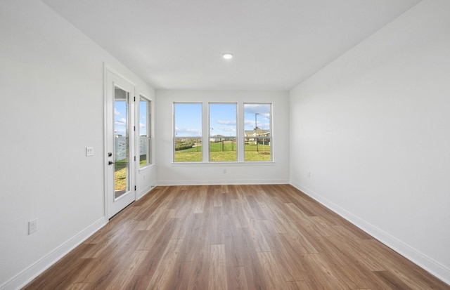 spare room with wood finished floors and baseboards