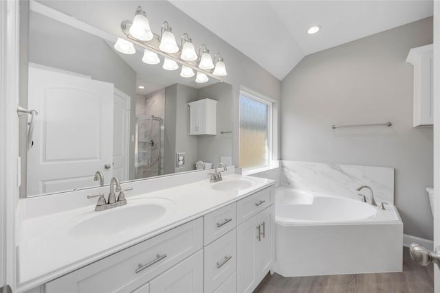 full bath with lofted ceiling, a stall shower, a sink, and a bath