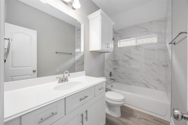 bathroom featuring wood finished floors, vanity, toilet, and shower / bathtub combination