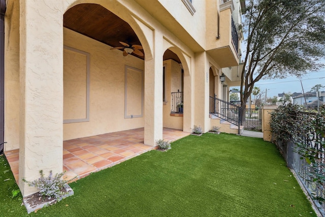 view of yard with a ceiling fan, fence, and a patio