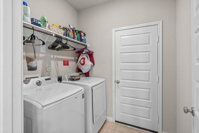 washroom with light tile patterned floors, laundry area, and washer and dryer