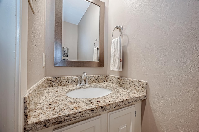 bathroom featuring a textured wall and vanity