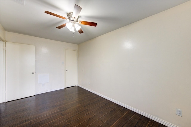 spare room featuring a ceiling fan, dark wood-style flooring, visible vents, and baseboards