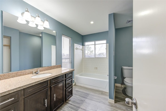 full bath with visible vents, toilet, vanity, wood finished floors, and baseboards