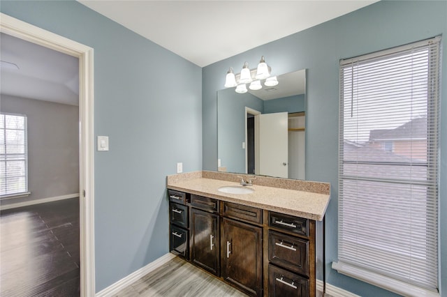 bathroom featuring baseboards, wood finished floors, and vanity