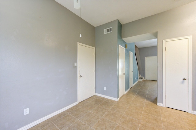 spare room with light tile patterned floors, visible vents, and baseboards