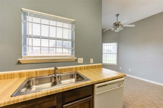 kitchen featuring dark brown cabinetry, white dishwasher, light countertops, a sink, and light tile patterned flooring