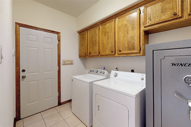 clothes washing area featuring cabinet space, light tile patterned floors, baseboards, and washing machine and clothes dryer