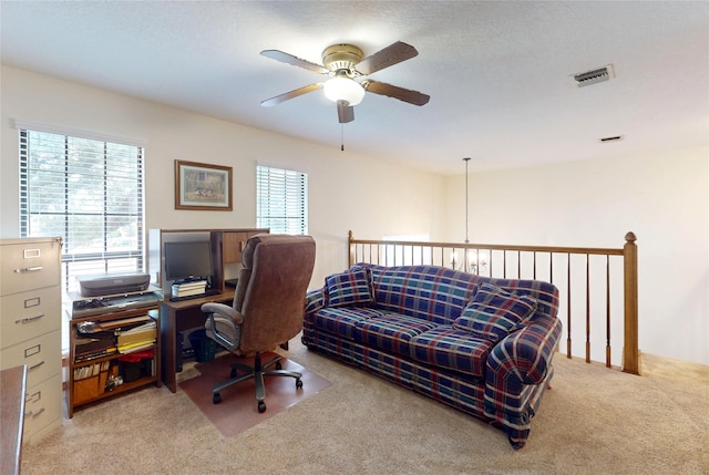 office with ceiling fan, visible vents, and light colored carpet