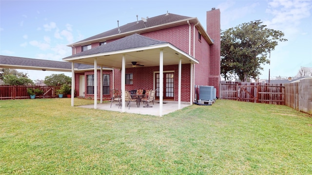 back of property featuring central AC unit, brick siding, a ceiling fan, a lawn, and a patio area