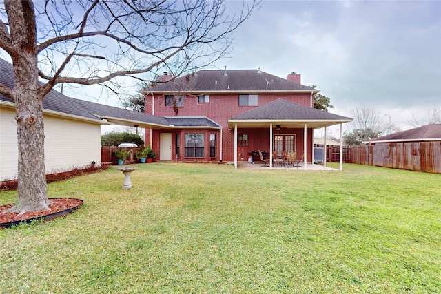 back of house featuring brick siding, a chimney, a ceiling fan, a patio area, and a fenced backyard