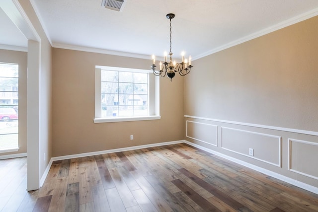 unfurnished room featuring a chandelier, wood finished floors, visible vents, and crown molding