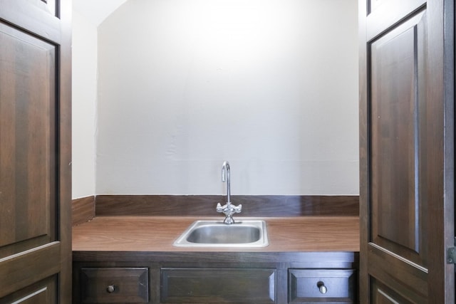 interior space with dark countertops, dark brown cabinets, and a sink