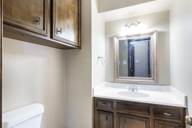 half bath featuring toilet and vanity