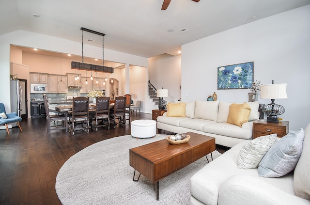 living area featuring ceiling fan, recessed lighting, dark wood-type flooring, visible vents, and stairway