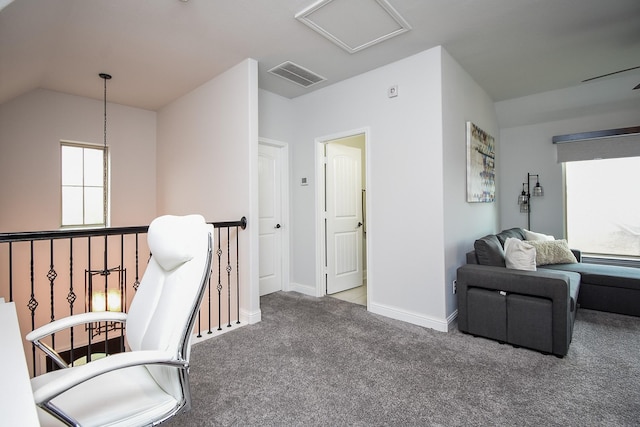 sitting room featuring lofted ceiling, an upstairs landing, visible vents, baseboards, and carpet