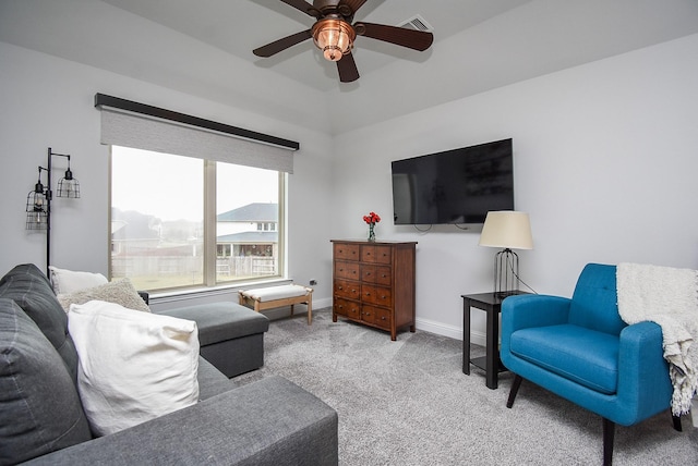 living area featuring light carpet, ceiling fan, visible vents, and baseboards