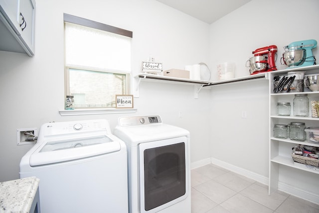 washroom with cabinet space, washer and clothes dryer, baseboards, and light tile patterned flooring