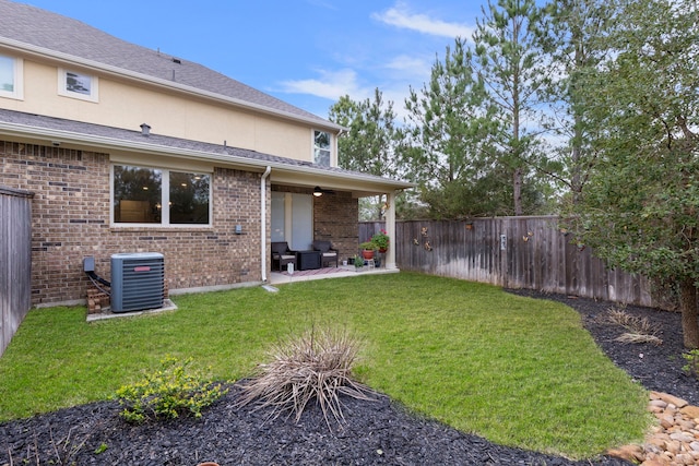 view of yard featuring central air condition unit, a fenced backyard, and a patio