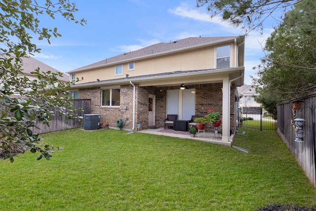 back of house featuring brick siding, a patio, stucco siding, a lawn, and a fenced backyard