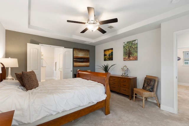 bedroom featuring baseboards, visible vents, a raised ceiling, light colored carpet, and ceiling fan