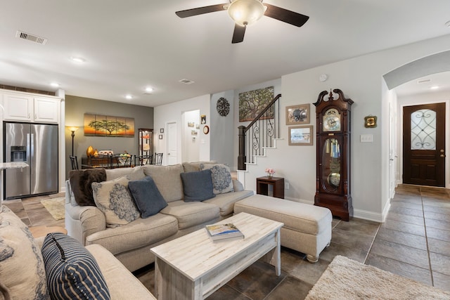 living area featuring arched walkways, stairs, visible vents, and recessed lighting