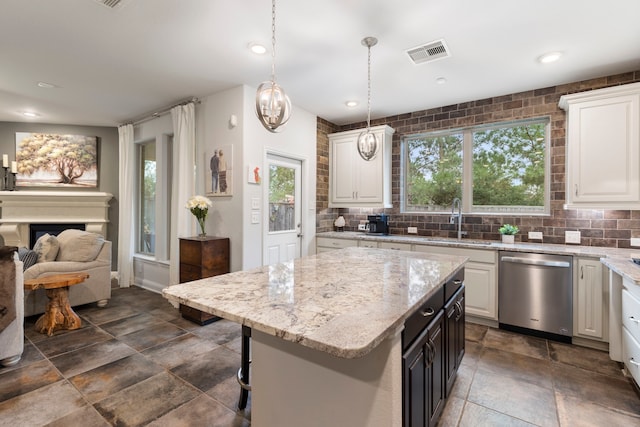 kitchen with visible vents, hanging light fixtures, white cabinetry, a sink, and dishwasher