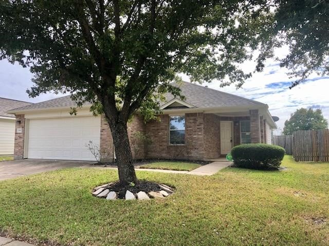 single story home featuring an attached garage, brick siding, a front yard, and fence