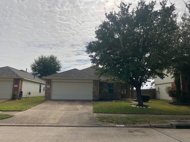 view of front of home featuring an attached garage, brick siding, concrete driveway, and a front yard