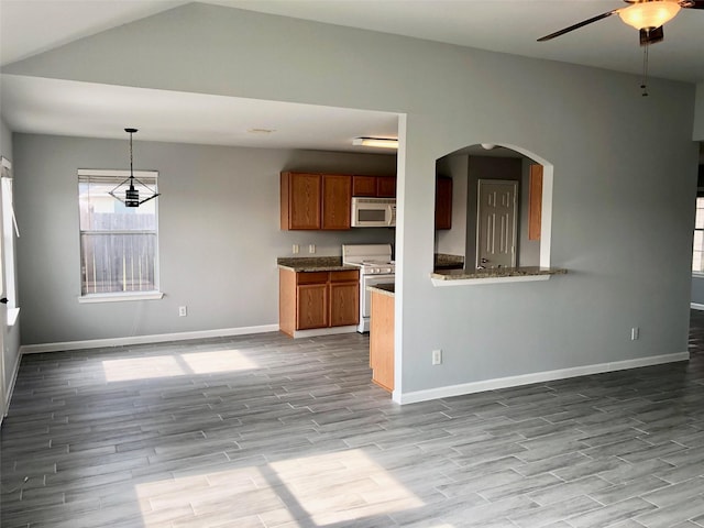 kitchen with pendant lighting, brown cabinets, light wood finished floors, a ceiling fan, and white appliances