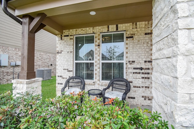 doorway to property with cooling unit and brick siding