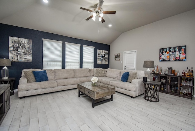 living area featuring light wood-type flooring, a dry bar, vaulted ceiling, and a ceiling fan