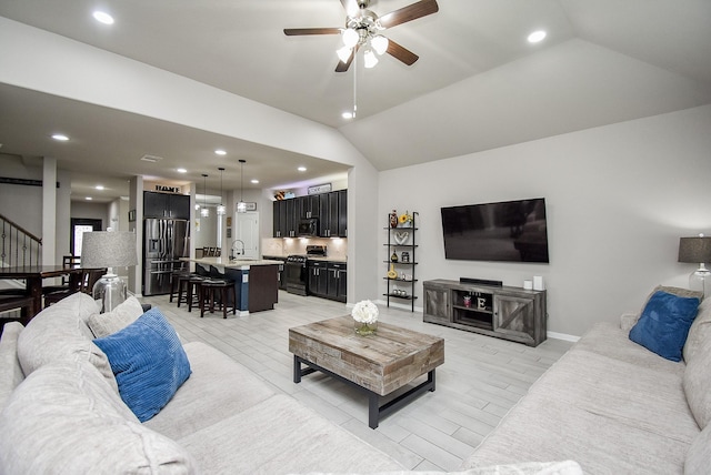 living room with recessed lighting, a ceiling fan, baseboards, vaulted ceiling, and stairs